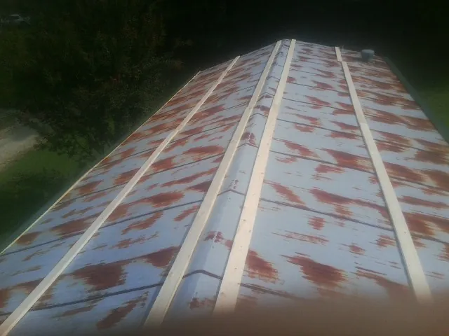 Rusted metal roof panels with new wood purlins before replacement — Storm Damage Roof Repair in Bean Station by Roofing Brothers