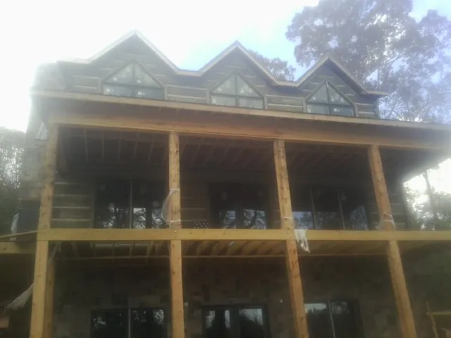 Dormers and porch framing on a large log home under construction — Roof Coating work by our crew in Bean Station
