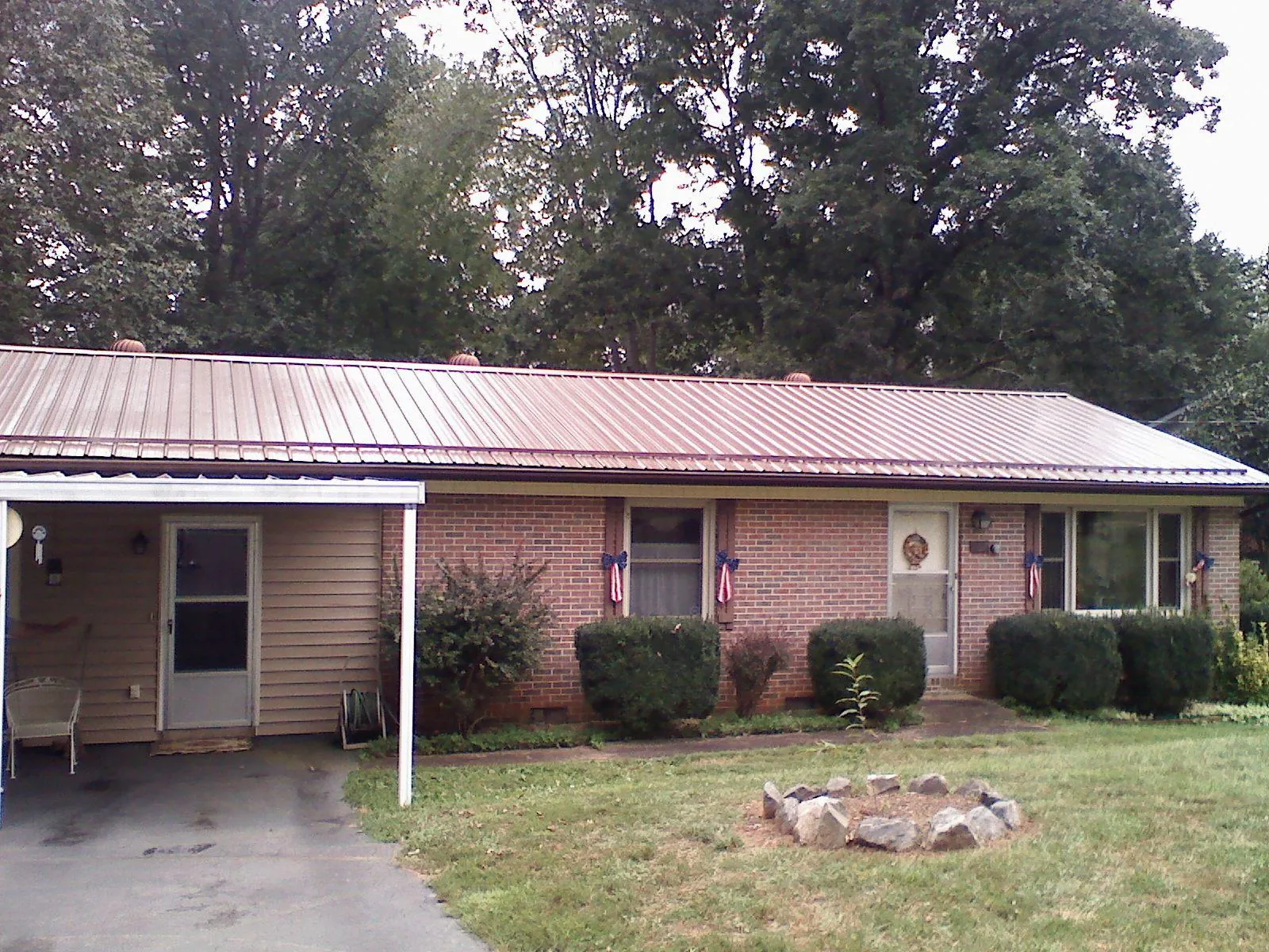 Bronze metal roof and carport on a brick ranch home — Roof Repair work by our crew in Bean Station